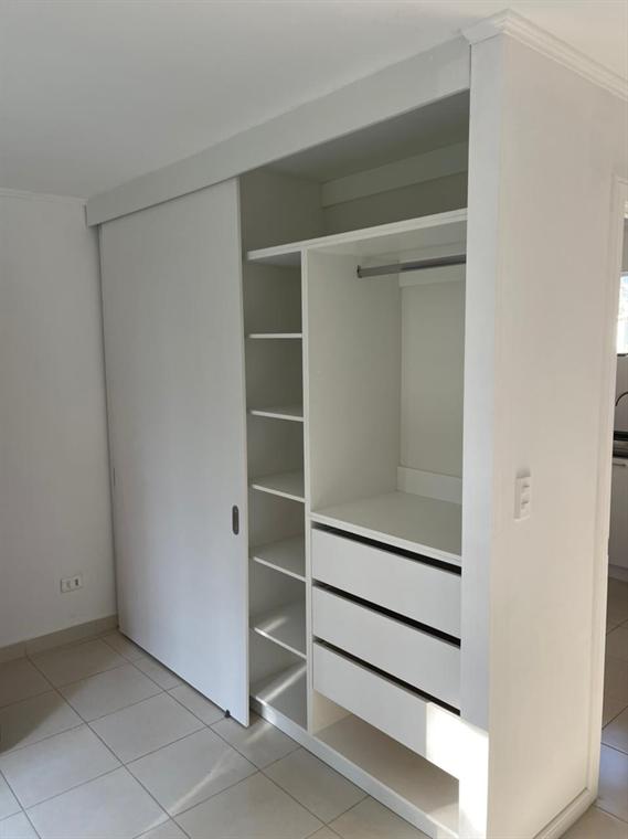 Closet blanco con puertas correderas y cajonería interior